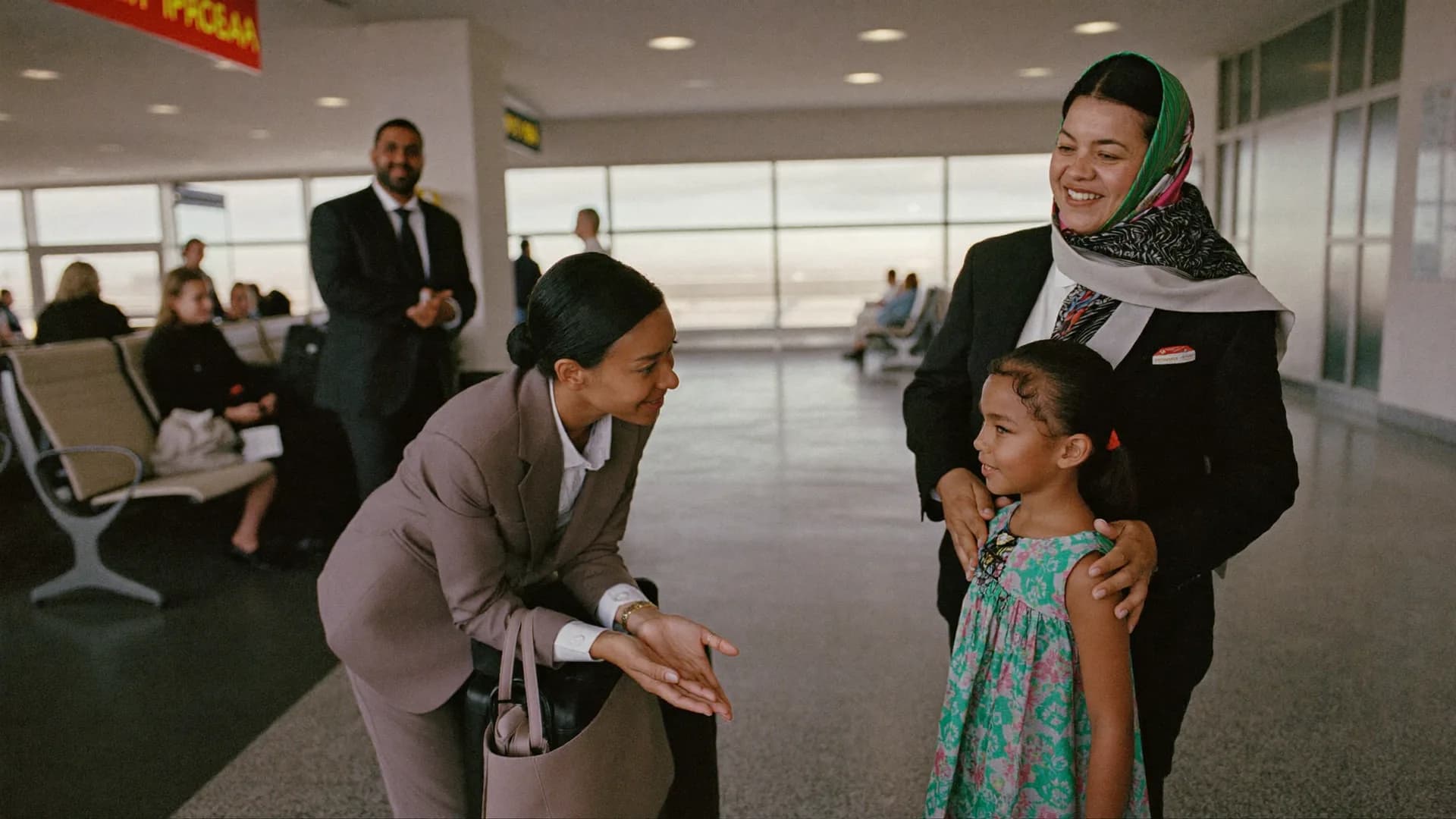 A Lioness Program specialist greeting a young girl at an airport while her mother looks on