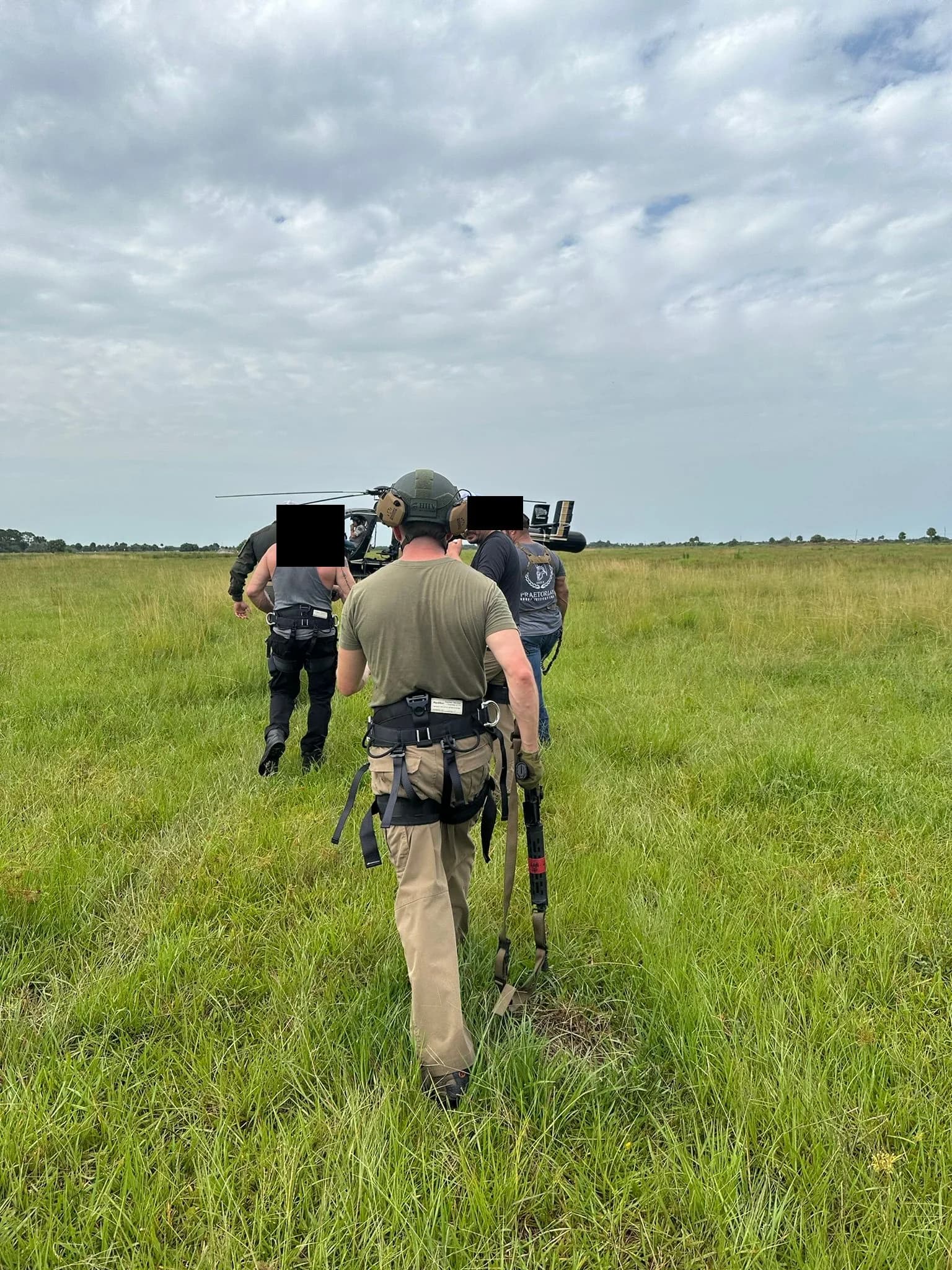 Candidates in flight harnesses walking to the helicopter for an insertion evolution