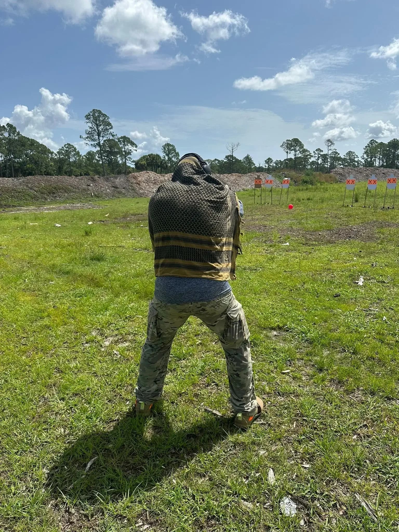 A candidate engaging steel targets downrange during a pistol evolution